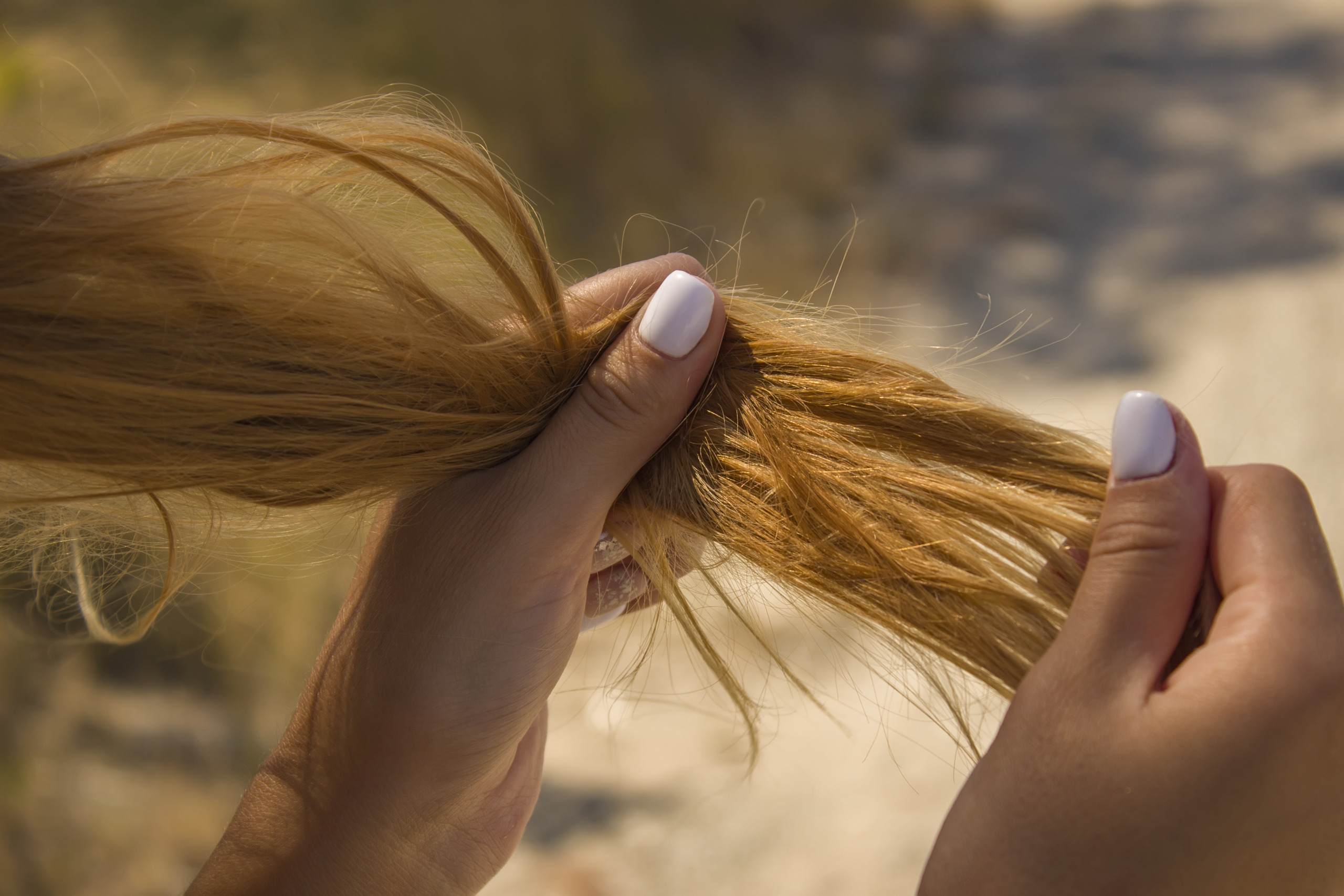 person holding dry, brittle hair