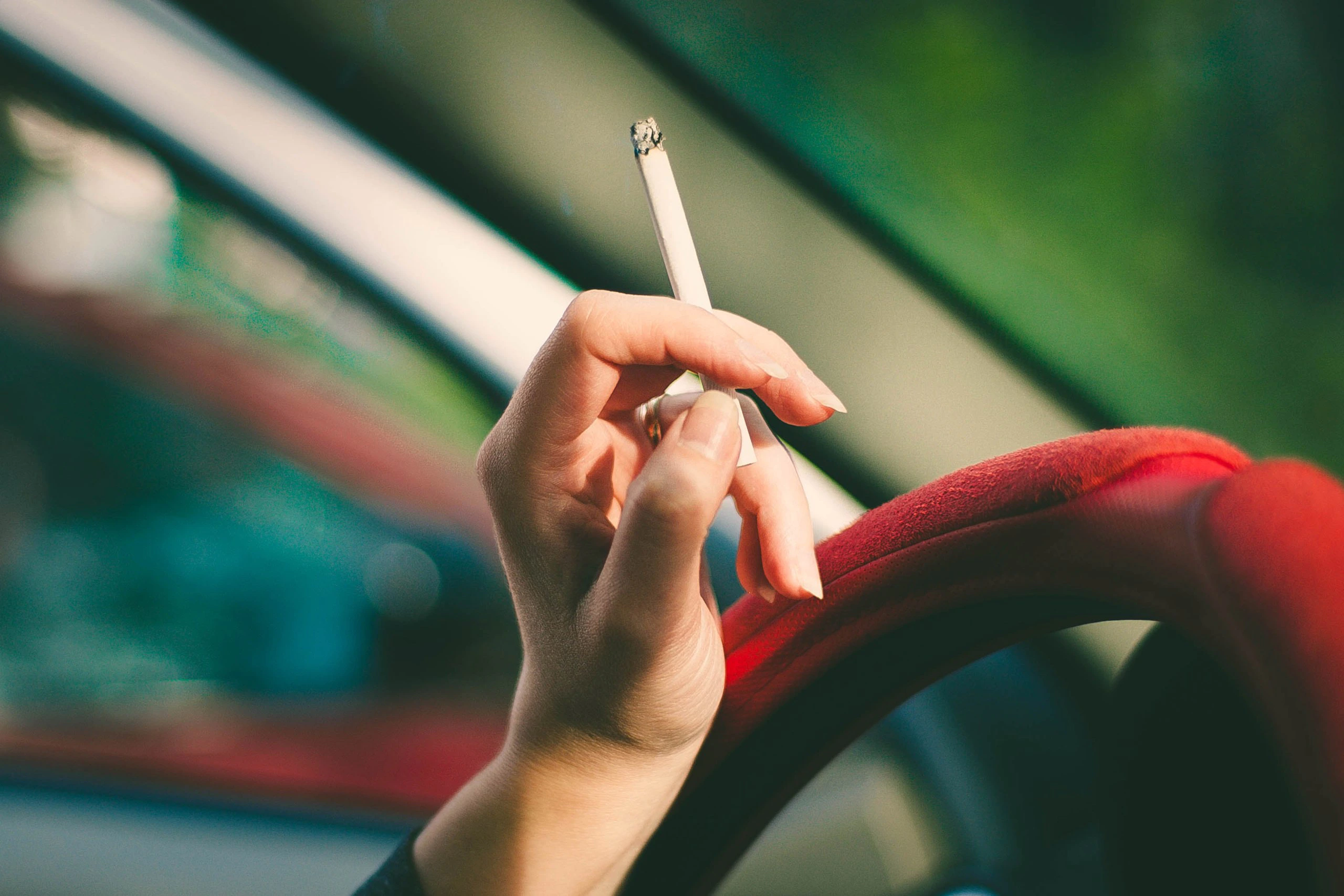 woman smoking a cigarette in the car